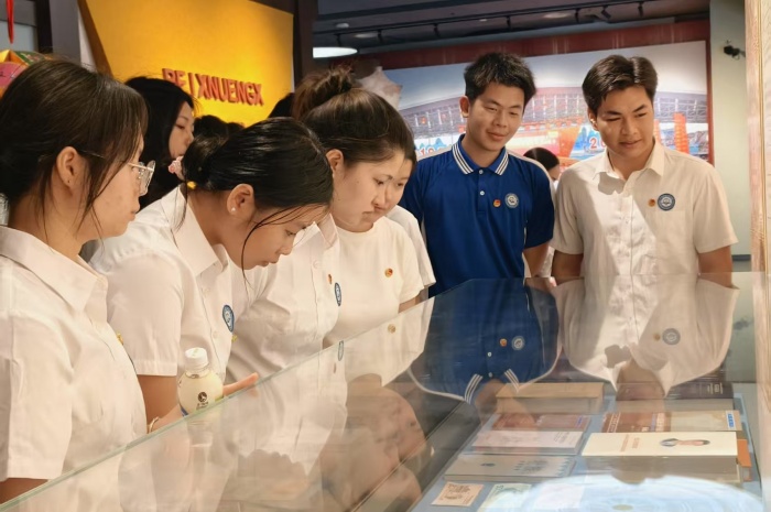 1747400966905029239.jpg 青年團員近(jìn)距離觀(guān)察錢幣展品上的壯(zhuàng)文.JPG.jpg